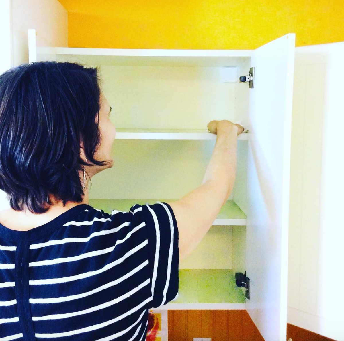 Woman wiping shelf clean